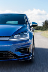 Fototapeta na wymiar Blue car detail in road with speed blur