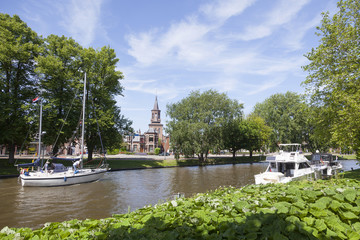 boats in canal near centre of old dutch town leeuwarden with church in the background