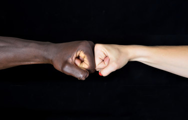 A hands of black man and white woman on black background