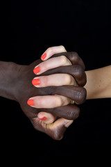 A hands of black man and white woman on black background
