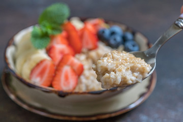 Bowl of delicious steel cut oats with fresh fruit, honey