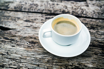 Coffee cup on wooden table background, top view