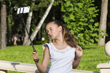 Girl doing selfie phone in a summer park 