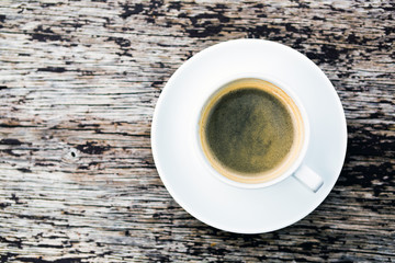 Coffee cup on wooden table background, top view
