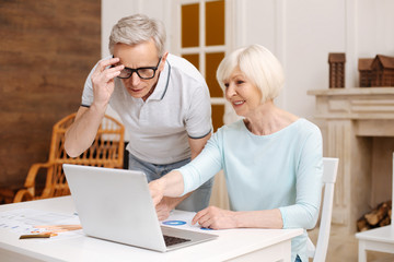 Smart analytical elderly gentleman having a look at the data