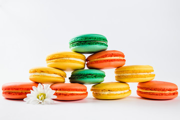 Multicolored macaroons (orange, yellow and green) close.