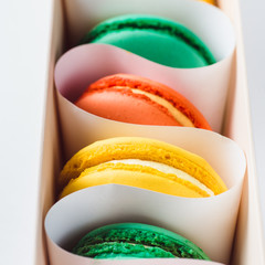 Set of different french cookies macaroons in a paper box. Top view close.