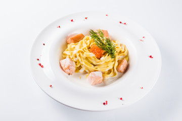 Creamy pasta. Fettuccine with salmon fillet in a mild cream sauce with red caviar (close)