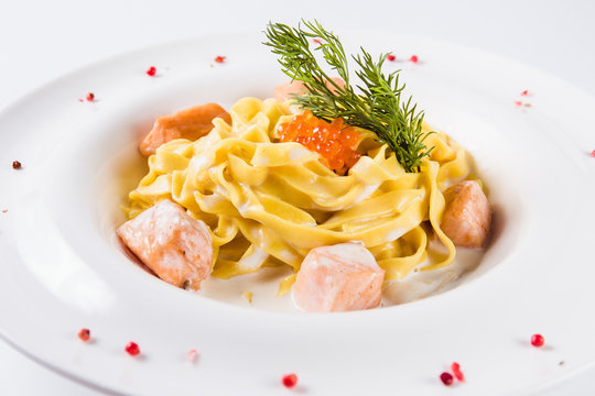 Creamy pasta. Fettuccine with salmon fillet in a mild cream sauce with red caviar (close)