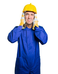 Worried workman covering his ears with his hands on white background