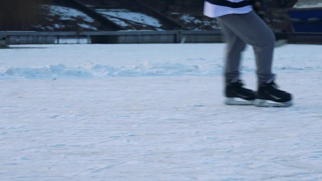 People play hockey on a frozen river, a player is passed a puck, travels with