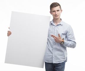 Young happy man portrait of a confident businessman showing presentation, pointing paper placard gray background. Ideal for banners, registration forms, presentation, landings, presenting concept.