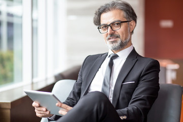 Confident successful senior man relaxing in hall