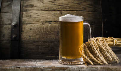 Beer in mug on wooden table near brick wall