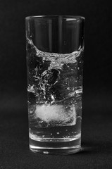 Glass of water with ice on a dark background