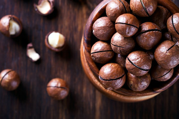Macadamia Nut in Shell on Wooden Background.Vegetarian.Concept of Healthy Food. selective focus.