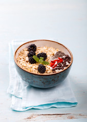 Oatmeal,Granola with Yoghurt, with Fresh berries,Blackberries,Goji berries,Chia seeds,chocolate.Healthy dry Breakfast.Diet Concept.Copy space for Text.selective focus.