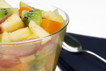 Detox fruit salad close in the side of the frame with a napkin and a spoon in the background
