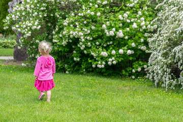 Girl in pink walking through garden