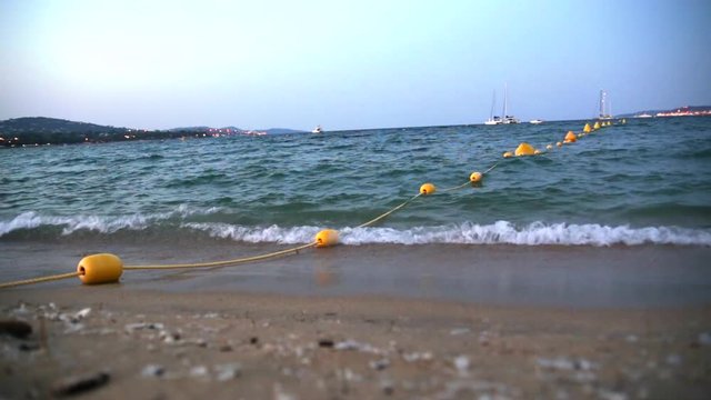 Yellow buoys on the coast, wavy Mediterranean sea