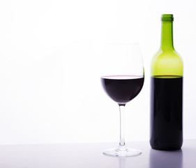 Cup and empty wine bottle on white background.