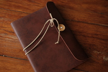 vintage leather notebook cover putting on wooden are background. image for business,education and abstract concept