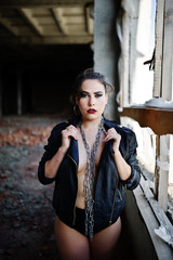 Brunette plus size sexy woman, wear at black leather jacket, lace panties and chain at abadoned...
