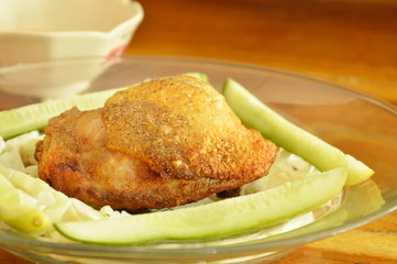 fried chicken thigh dressing salt and pepper with vegetable on plate