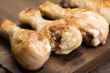 Roasted chicken thigh meat served on wooden board.