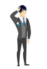 Young asian groom scratching his head.