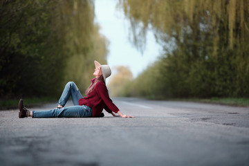 Young woman traveler sitting on road, nature, outdoor