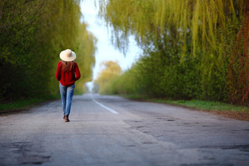 Obraz premium Beautiful woman walking back on road, traveling, nature, outdoor, in straw hat