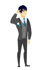 Groom gesturing with his finger against temple