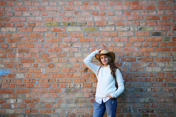 Fashion young woman standing, fashion, stylish with pink lips, hat, white shirt, outdoor, on brick background, fashion, street lifestyle, walking, copy space