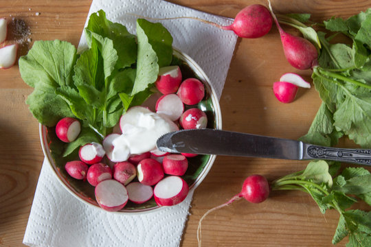 Radish with fresh herbs and sour cream. Vitamin salad with parsley and green onions. Healthy food. Top view.