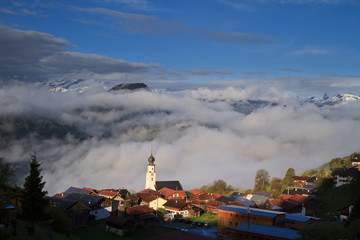 Alpine village at sunrise clouds