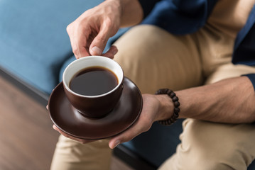 Youthful man spending time with favourite beverage at home