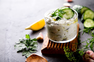 Tzatziki Traditional Greek sauce with ingredients cucumber, garlic, parsley, lemon, mint. Food Background.Snack, Meze in a glass cup.Copy space for Text.selective focus.