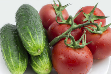 Tomatoes and cucumbers on a white background