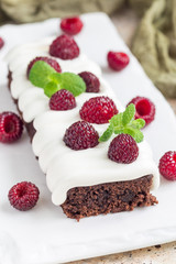 Homemade brownies with cream cheese frosting and raspberry