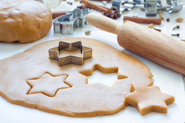 Making gingerbread cookies. Dough, metal cutter and rolling pen on wooden table, spices on...