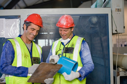 Workers reading clipboards in factory