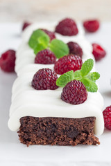 Homemade brownies with cream cheese frosting and raspberry, vertical