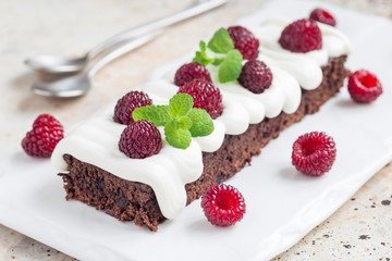 Homemade brownies with cream cheese frosting and raspberry, horizontal
