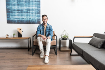 Joyful youthful guy having rest at home