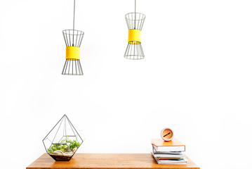 Domestic watch with stack of notepads and flowerpot on desktop