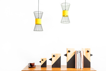 Mug and statuettes for interior decor with books on desktop