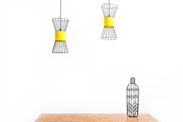 Metallic shape of bottle on desktop and lamps on ceiling