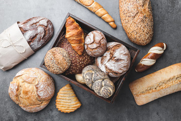 A basket full of delicious fresh bread on wooden background