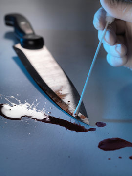 Scientist swabbing bloody knife